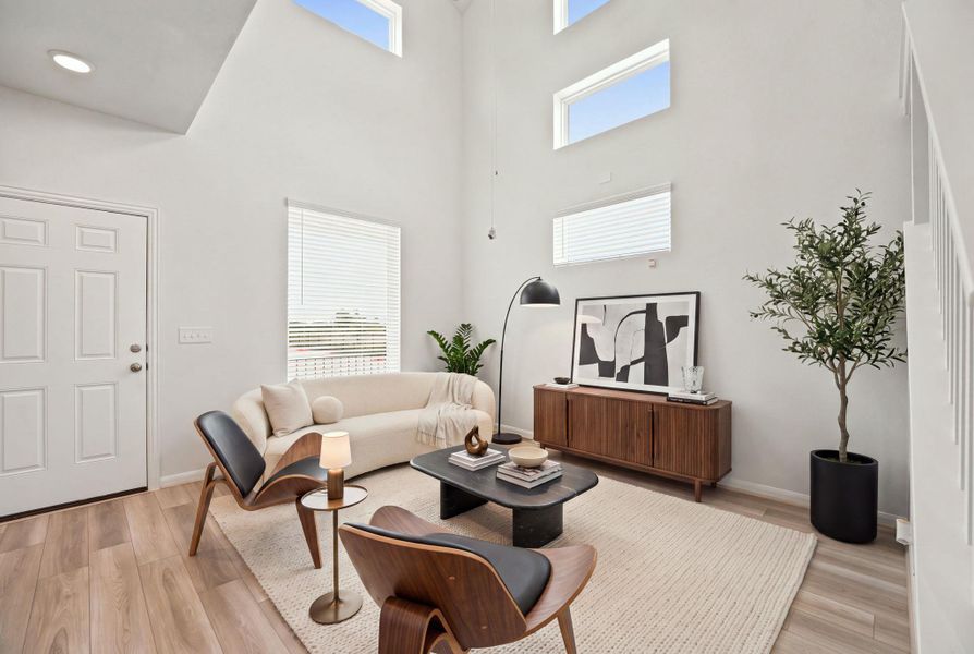 Hardwood floors and soaring double-height ceilings define this modern living space.