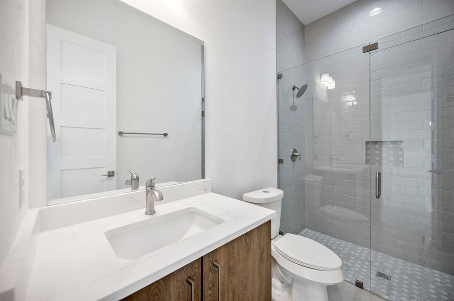 Bathroom with vanity, a stall shower, and toilet Bathroom with vanity, a stall shower, and toilet