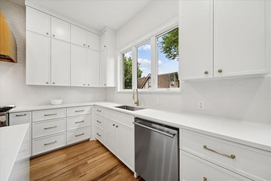 Kitchen with sink, dishwasher and white cabinetry