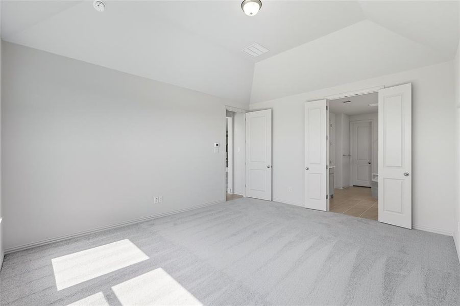 Unfurnished bedroom featuring light carpet and vaulted ceiling Unfurnished bedroom featuring light carpet and vaulted ceiling