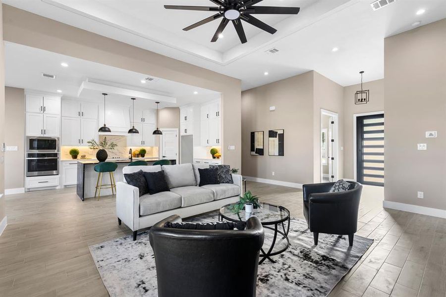 Living room with a raised ceiling and ceiling fan