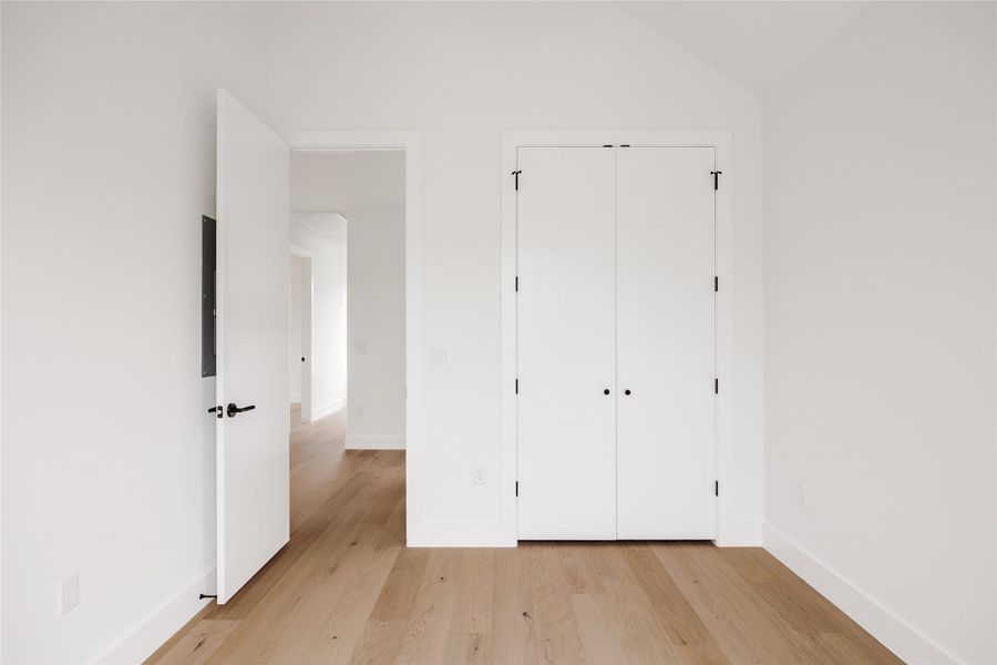 Unfurnished bedroom featuring light wood-style flooring and a closet