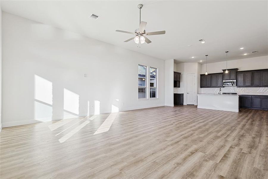 Unfurnished living room with light hardwood / wood-style floors and ceiling fan