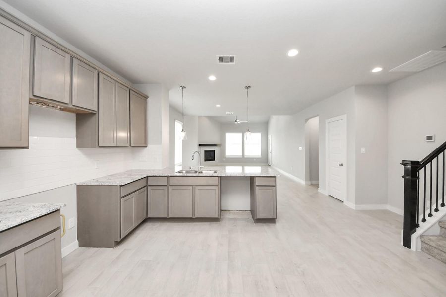 This kitchen is truly a chef's dream! This haven Boasts high ceilings, recessed lighting, stained wood cabinets, granite countertops, stainless steel appliances, a modern tile backsplash. All of this overlooks your expansive family room, creating a perfect space for culinary delights and family gatherings. Sample photo of completed home with similar floor plan. Actual colors and selections may vary. This kitchen is truly a chef's dream! This haven Boasts high ceilings, recessed lighting, stained wood cabinets, granite countertops, stainless steel appliances, a modern tile backsplash. All of this overlooks your expansive family room, creating a perfect space for culinary delights and family gatherings. Sample photo of completed home with similar floor plan. Actual colors and selections may vary.