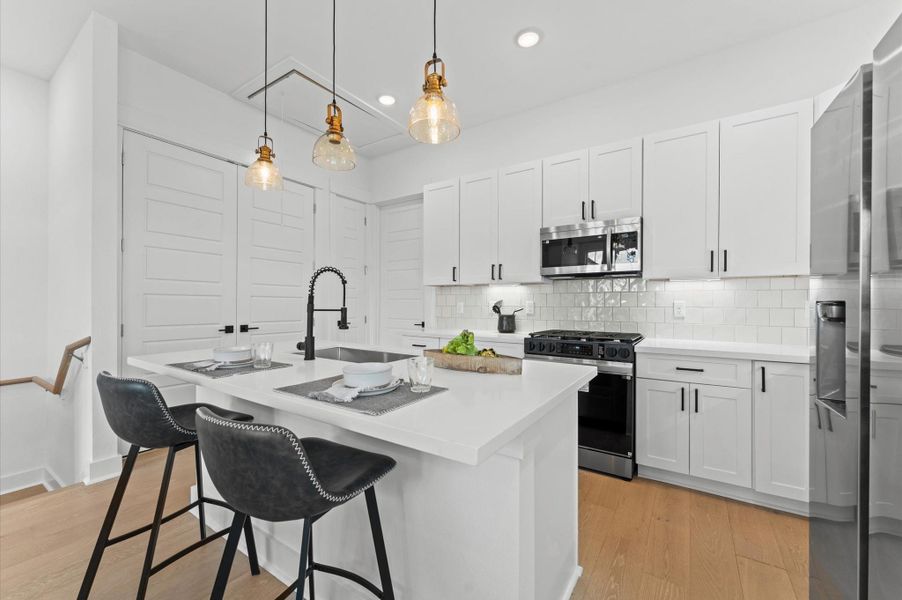 This stylish kitchen features sleek quartz countertops that offer both durability and elegance, paired with a spacious center island perfect for meal prep and casual dining. Surrounding the space is a generous array of cabinets, providing ample storage while maintaining a clean, streamlined look. The open layout and contemporary finishes create a welcoming atmosphere ideal for both everyday living and entertaining.