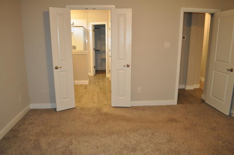 Unfurnished bedroom featuring a spacious closet and light carpet