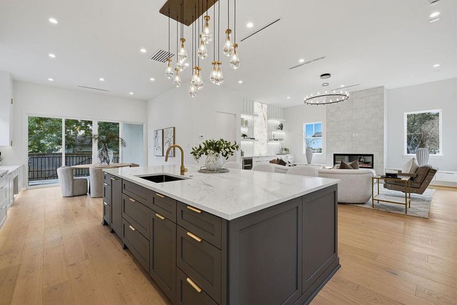 From the kitchen, the home opens into a sprawling family room designed for grand-scale entertaining and daily relaxation. The space is bathed in natural light from expansive windows and sliding glass doors that lead to the outdoor living area.