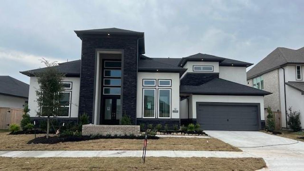 Front exterior of a new home in Bridgeland 45', 50', 70', Cypress, TX, highlighting curb appeal (Image 1). Front exterior of a new home in Bridgeland 45', 50', 70', Cypress, TX, highlighting curb appeal (Image 1).