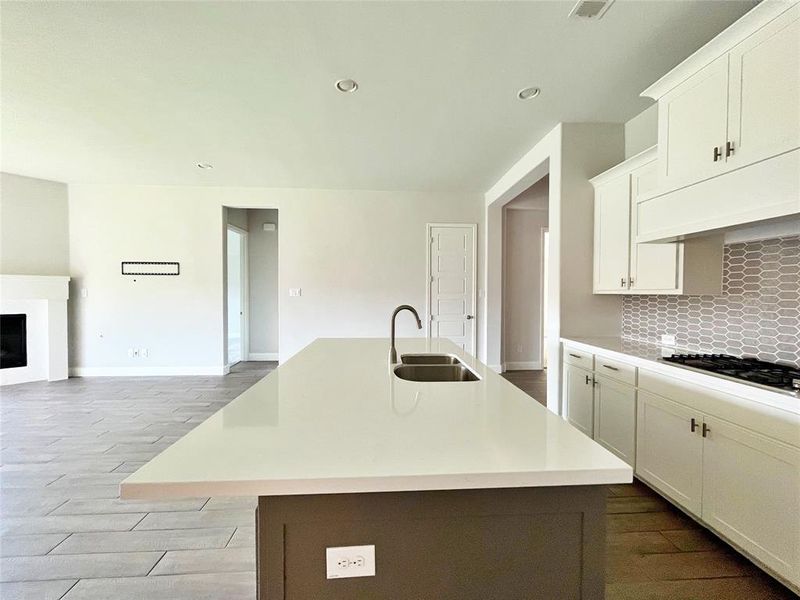 Kitchen featuring tasteful backsplash, dark wood finished floors, white cabinets, recessed lighting, and a center island with sink Kitchen featuring tasteful backsplash, dark wood finished floors, white cabinets, recessed lighting, and a center island with sink