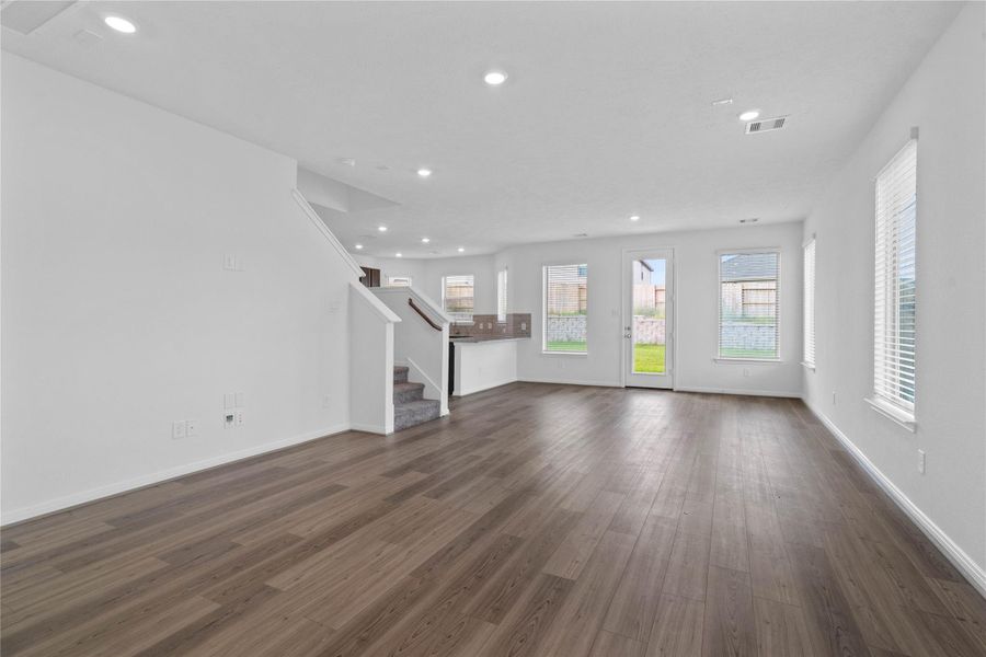 The open concept living room and kitchen makes for a great way to keep the party going and never miss a beat. Designed for comfort and connection, it features Emerald Hollow vinyl plank flooring, large windows with blinds, high ceilings and recessed lighting.