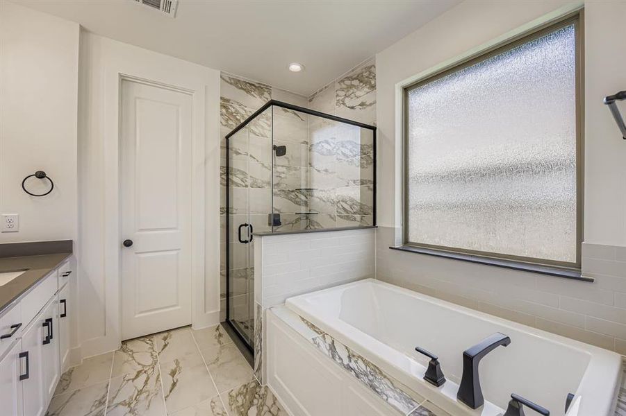 Bathroom featuring a marble finish shower, vanity, light marble finish flooring, a garden tub, and recessed lighting