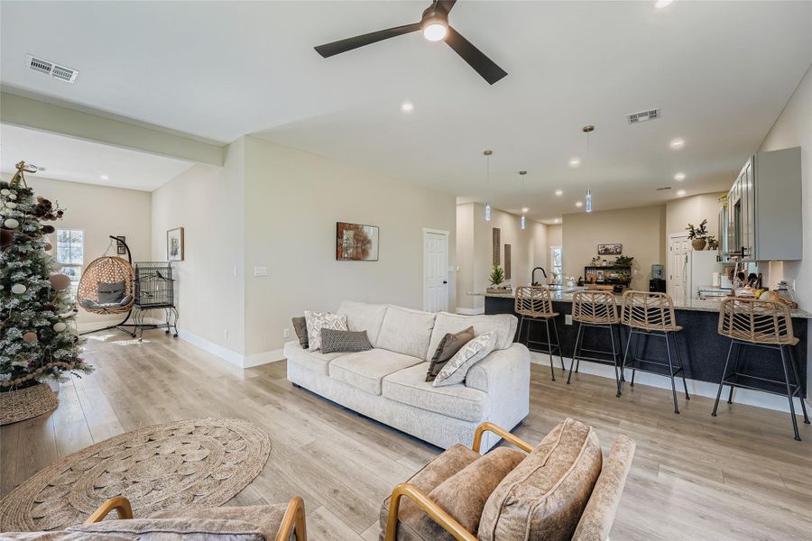 Living room featuring light wood finished floors, a ceiling fan, and recessed lighting Living room featuring light wood finished floors, a ceiling fan, and recessed lighting