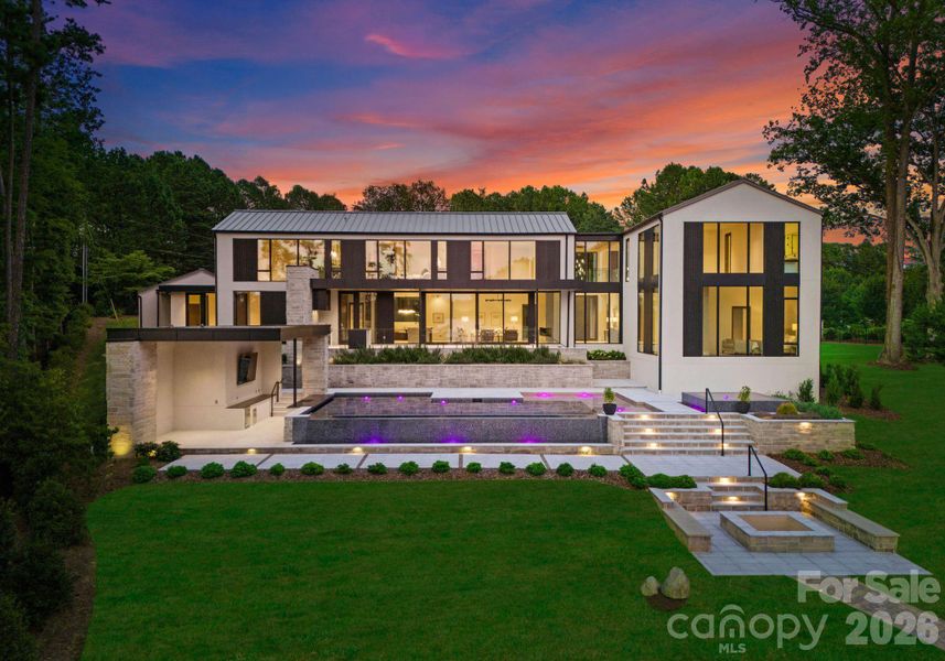 Backyard featuring the infinity pool and spa, and the pool cabana with a swim-up bar, 100" TV, dining area, half bathroom, and changing area. Backyard featuring the infinity pool and spa, and the pool cabana with a swim-up bar, 100" TV, dining area, half bathroom, and changing area.