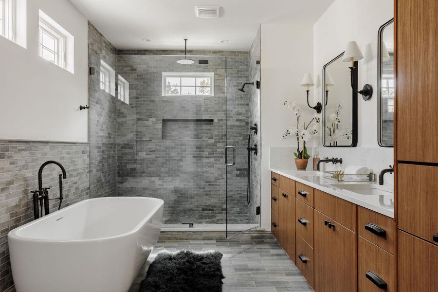 A spa-inspired retreat featuring dual vanities, quartzite surfaces, and an oversized soaking tub positioned for relaxation and reflection with a large walk-in shower. A spa-inspired retreat featuring dual vanities, quartzite surfaces, and an oversized soaking tub positioned for relaxation and reflection with a large walk-in shower.