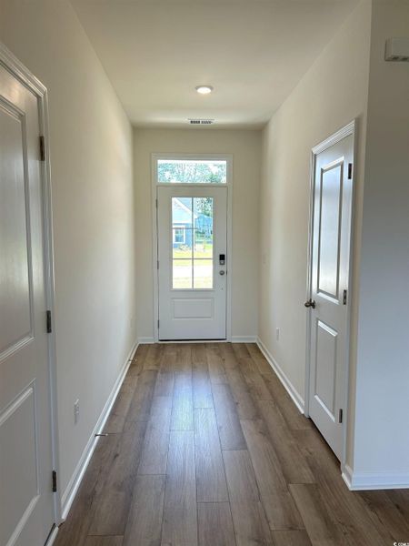 Doorway featuring baseboards and wood finished floors Doorway featuring baseboards and wood finished floors