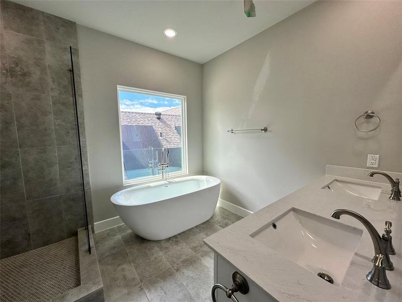 Primary Bathroom featuring dual bowl vanity, tile flooring, and plus walk in shower