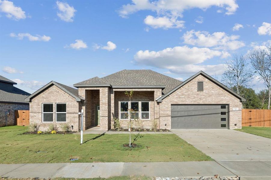 View of front of home with covered porch, brick siding, concrete driveway, a shingled roof, and an attached garage