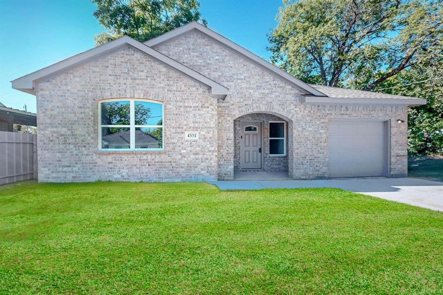 View of front of house with a front yard and a garage