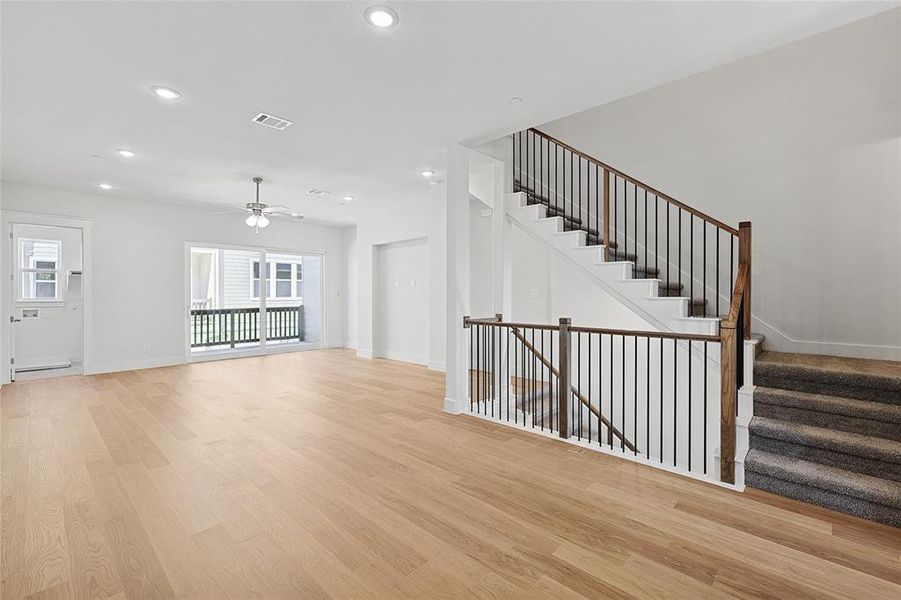 Unfurnished living room with ceiling fan, baseboard heating, and light wood-type flooring Unfurnished living room with ceiling fan, baseboard heating, and light wood-type flooring