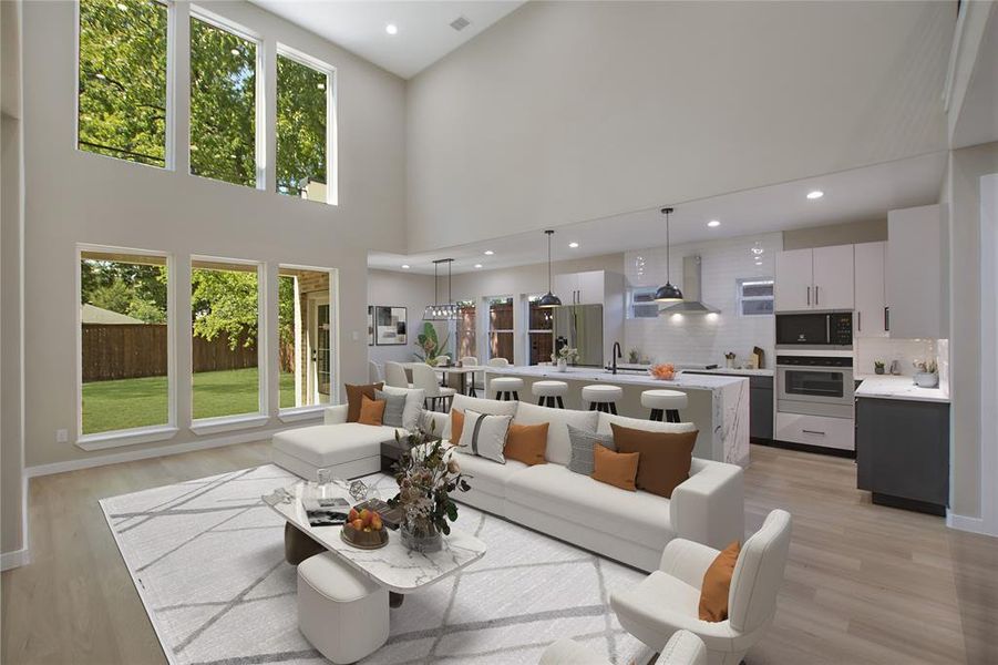 Living room with light wood-type flooring, a towering ceiling, and sink