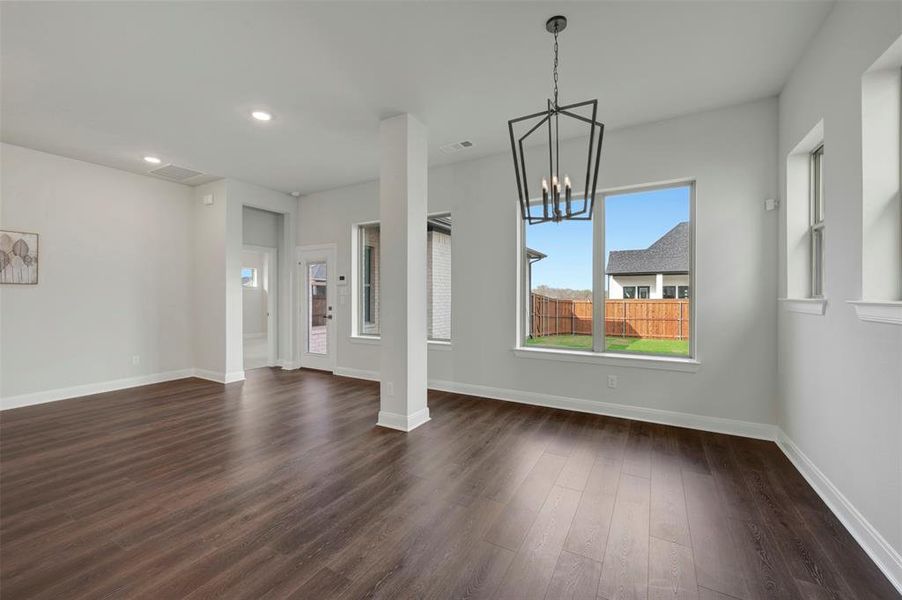 Unfurnished dining area with a chandelier and dark wood finished floors