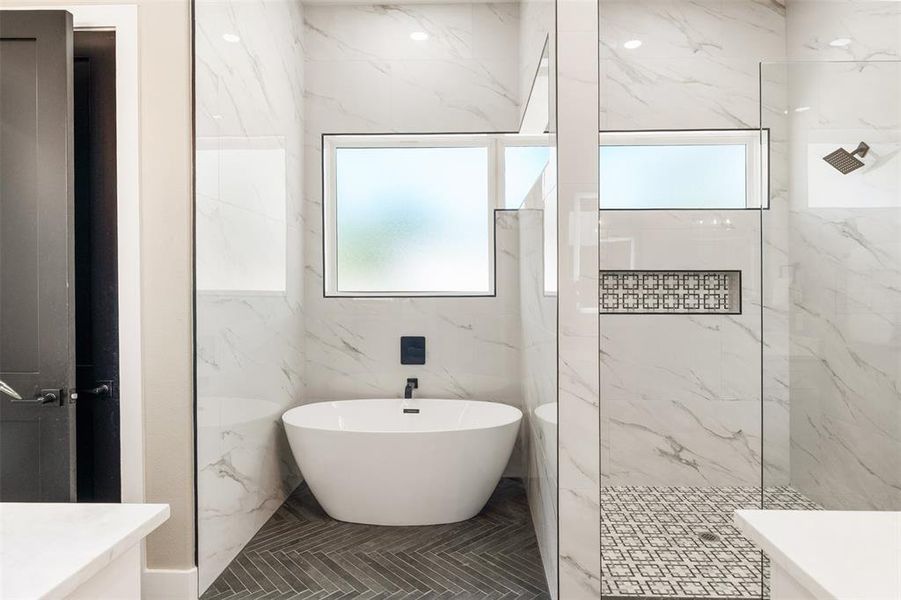 En-suite, soaking tub, separate shower, floor to ceiling tile, marble shower floor,  shampoo niche
