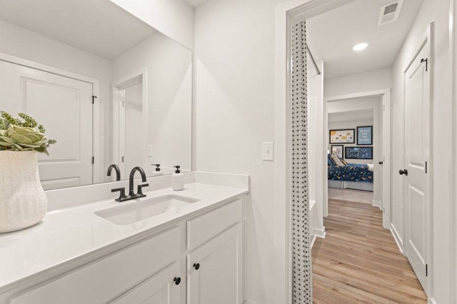 A bathroom with white cabinets.