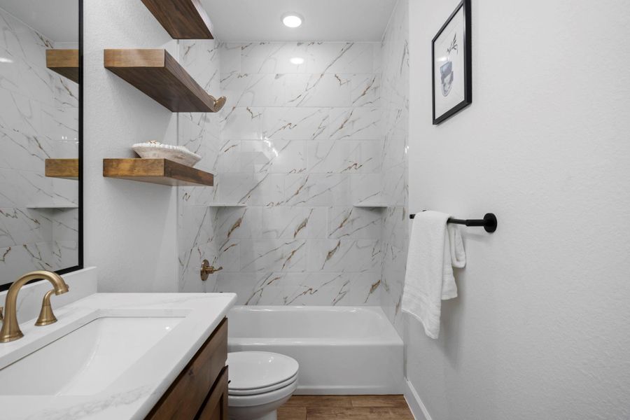 Full bathroom with vanity, shower / tub combination, and wood finished floors