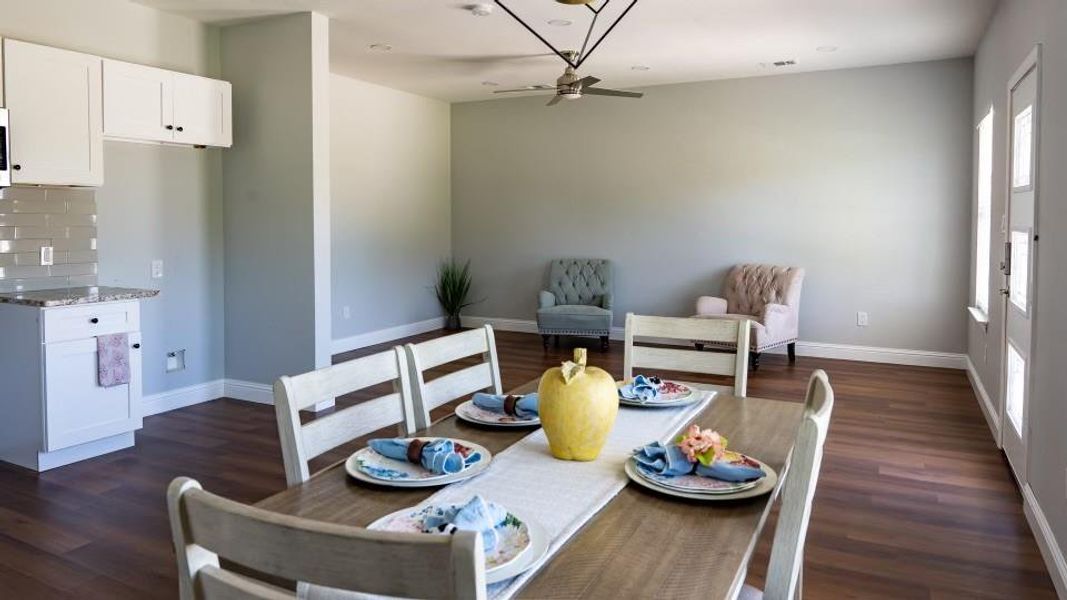 Dining area with ceiling fan and dark wood-type flooring Dining area with ceiling fan and dark wood-type flooring