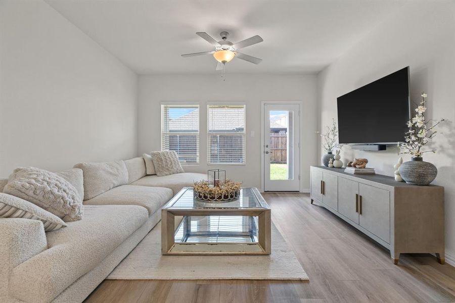 Living room with light wood-style floors and a ceiling fan Living room with light wood-style floors and a ceiling fan