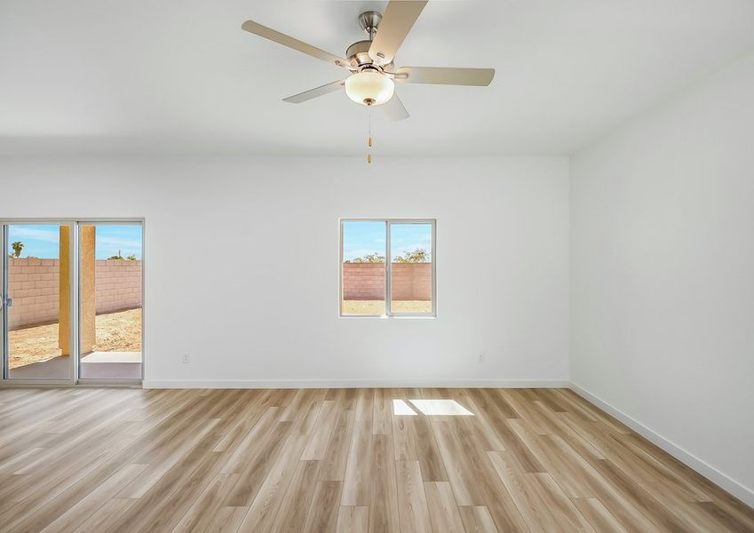 Family room with ceiling fan and windows in Wellton floor plan