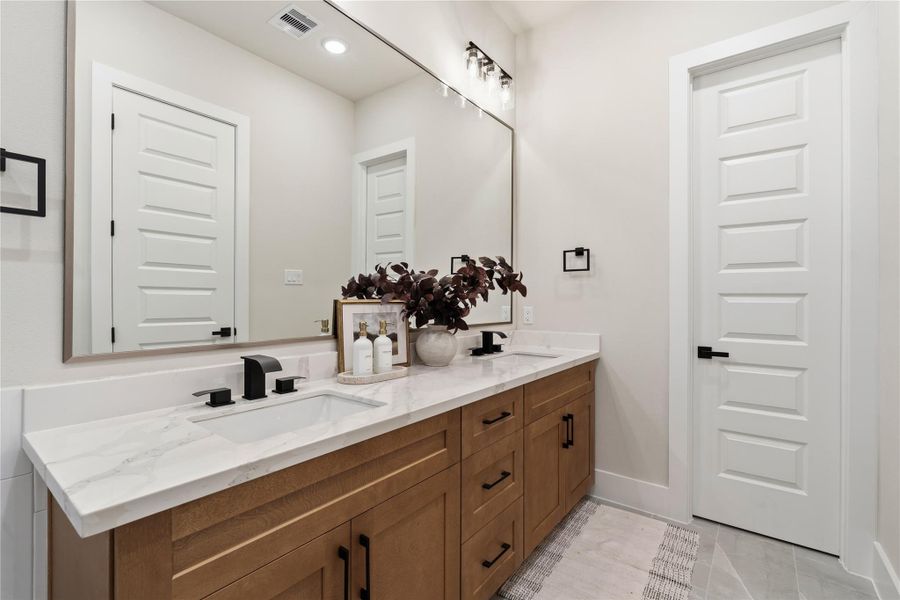 A spacious primary bath designed for daily ease, featuring a frameless glass shower and a wide dual vanity with plenty of counter space for a seamless routine. A spacious primary bath designed for daily ease, featuring a frameless glass shower and a wide dual vanity with plenty of counter space for a seamless routine.