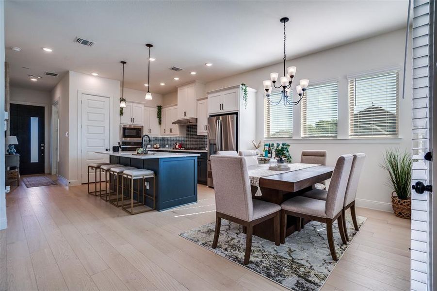 Dining area with light wood finished floors and a chandelier