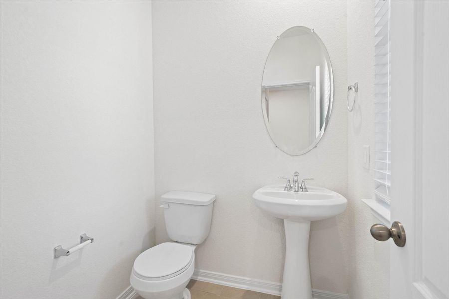 The powder room on the first floor includes a pedestal sink, mirror, and toilet to conveniently meet your needs. The powder room on the first floor includes a pedestal sink, mirror, and toilet to conveniently meet your needs.
