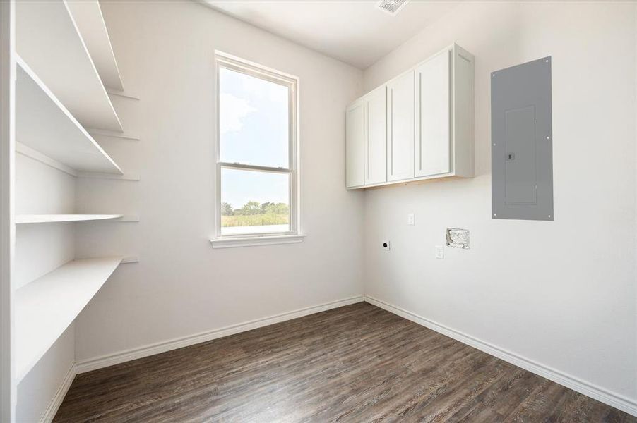 Clothes washing area with electric dryer hookup, cabinets, wood-type flooring, and electric panel