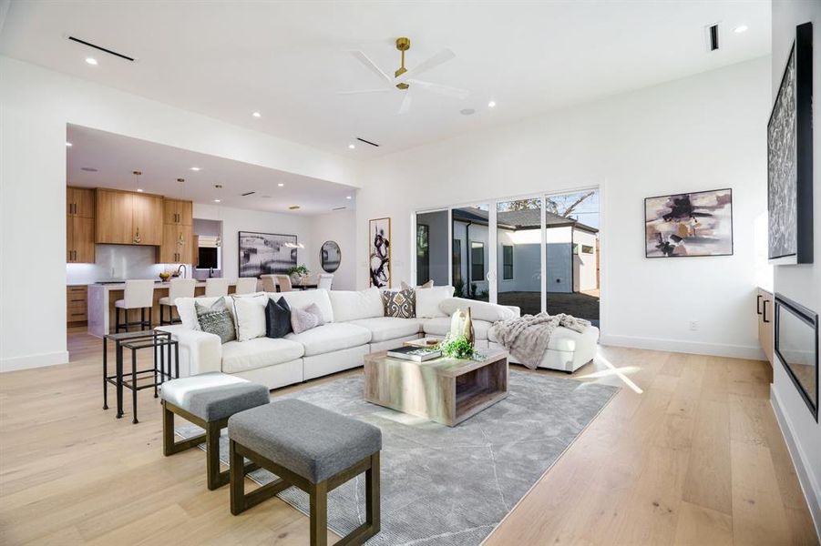 Living room with light hardwood / wood-style floors and ceiling fan