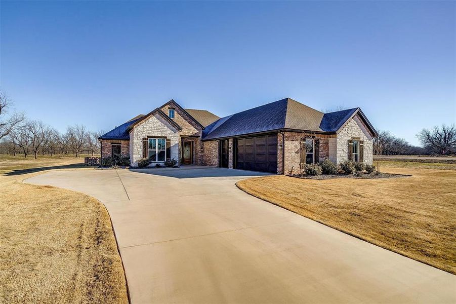 View of front of house with a garage and a front lawn