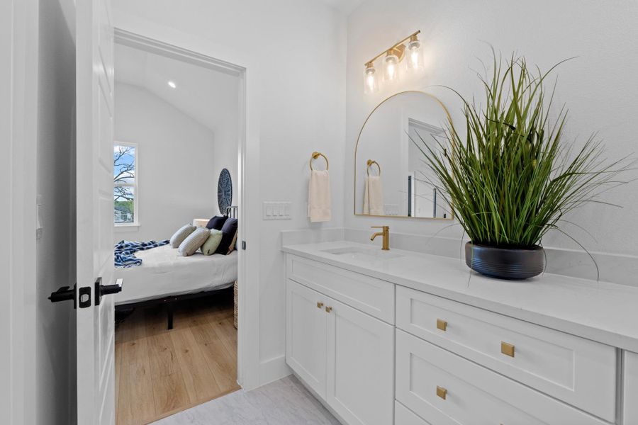 Bathroom with vanity, ensuite bathroom, lofted ceiling, recessed lighting, and light wood-type flooring