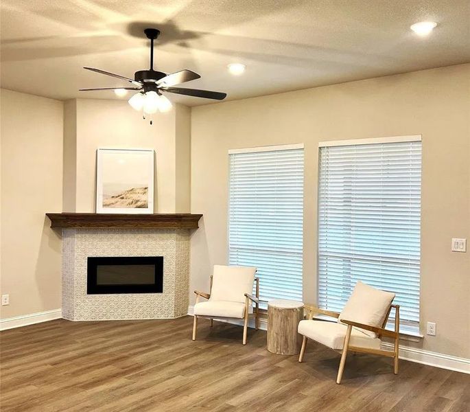 Corner fireplace with decorative tile surround and a dark wood mantel Corner fireplace with decorative tile surround and a dark wood mantel