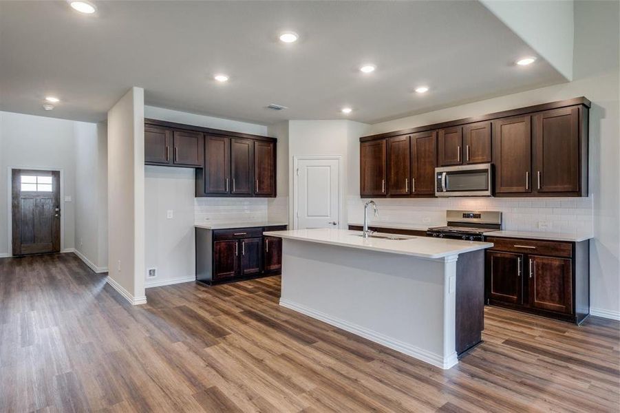 Kitchen featuring sink, appliances with stainless steel finishes, tasteful backsplash, and hardwood / wood-style floors