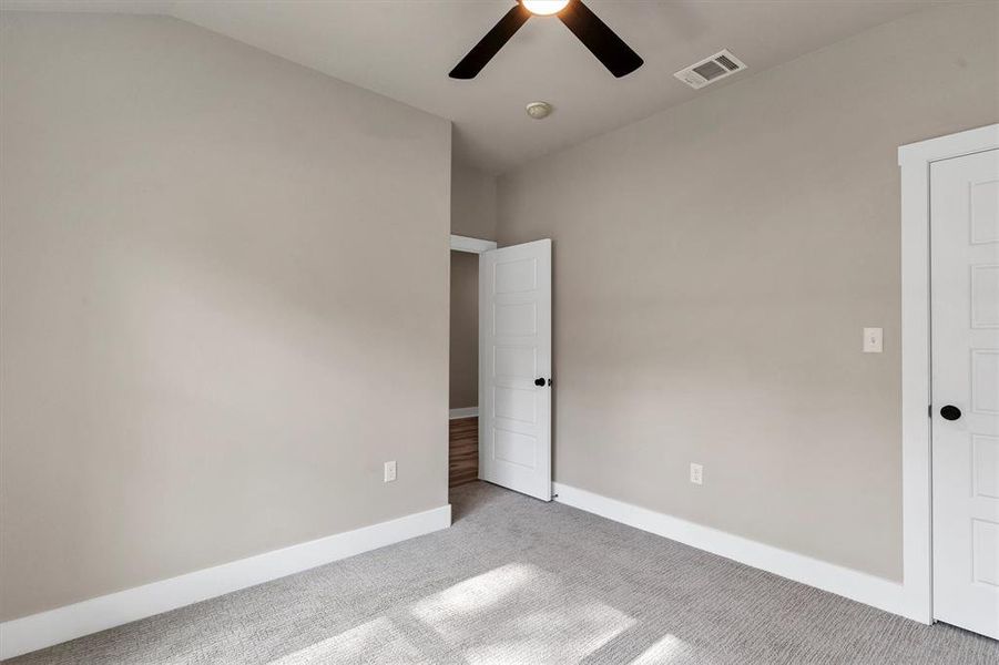 Unfurnished bedroom with carpet floors and a ceiling fan Unfurnished bedroom with carpet floors and a ceiling fan