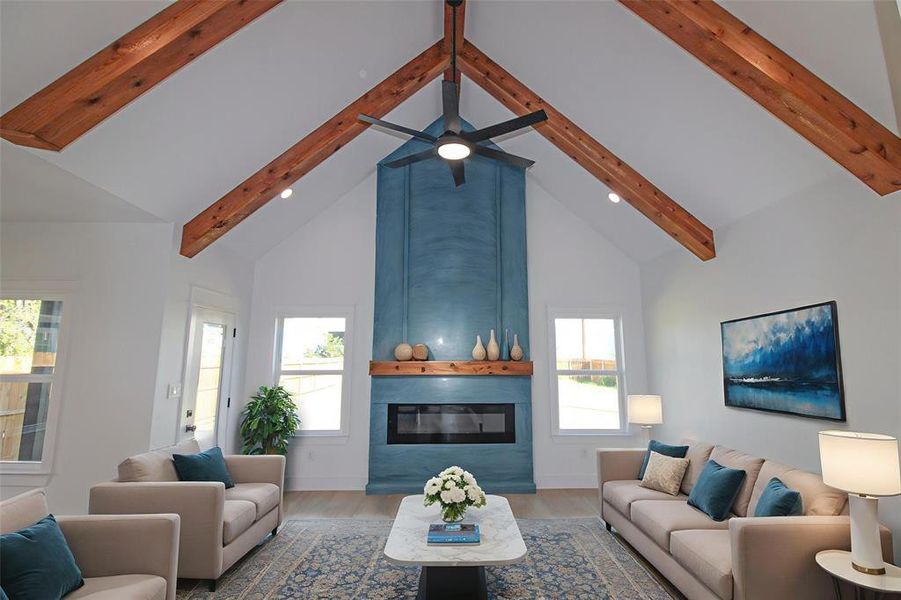 Living room featuring high vaulted ceiling, beamed ceiling, wood finished floors, a fireplace, and recessed lighting Living room featuring high vaulted ceiling, beamed ceiling, wood finished floors, a fireplace, and recessed lighting