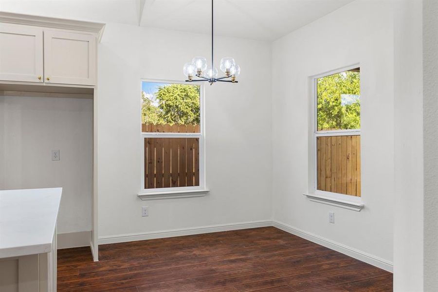 Unfurnished dining area with a notable chandelier and hardwood / wood-style floors