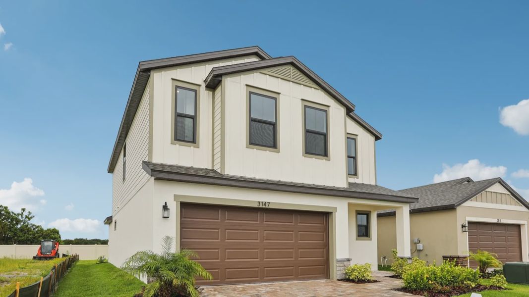 Front exterior of a new home in Grasslands West, Lakeland, FL, highlighting curb appeal (Image 22).