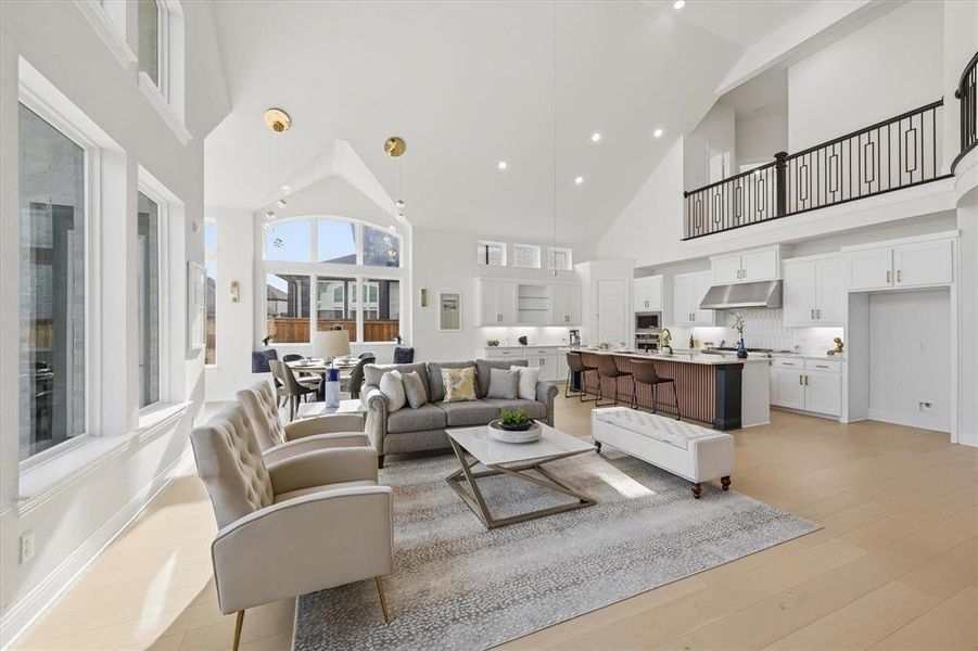 Spacious open-concept living area featuring a vaulted ceiling and light wood-finish flooring