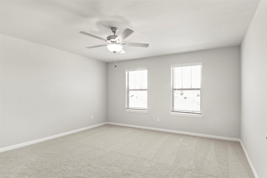 Spare room featuring light carpet, ceiling fan, and baseboards