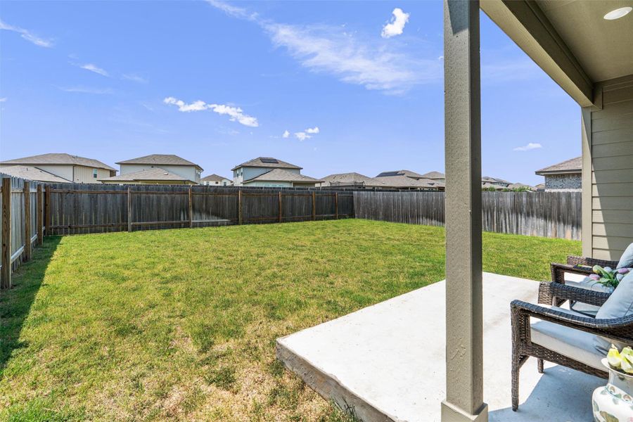 Fenced backyard featuring a patio and a residential view