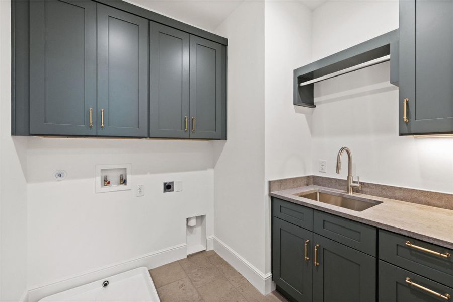 A well-appointed utility room features a deep sink with ample counter space and convenient hanging rack.