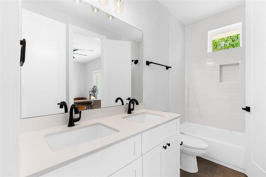 Double vanity sinks with matte black finishes create a timeless design while maximizing functionality of this shared bathroom.