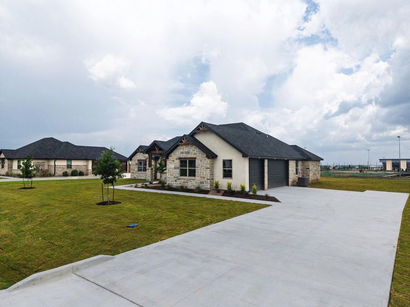 A well-maintained lawn embraces a contemporary home featuring a sturdy concrete driveway and attached garage. A well-maintained lawn embraces a contemporary home featuring a sturdy concrete driveway and attached garage.